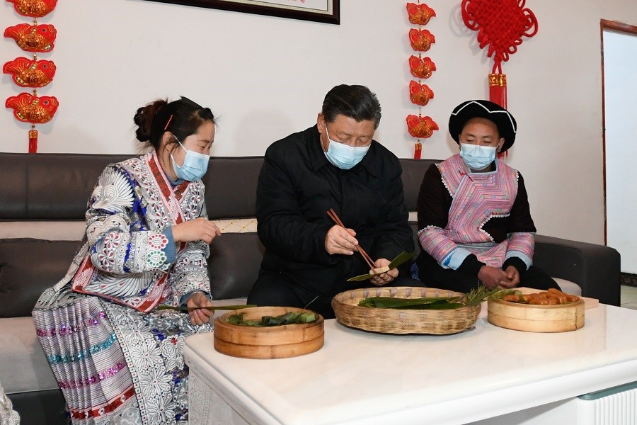 2021年2月3日下午，習(xí)近平在貴州畢節(jié)市黔西縣新仁苗族鄉(xiāng)化屋村苗族村民趙玉學(xué)家，同一家人邊聊家常邊制作當(dāng)?shù)貍鹘y(tǒng)節(jié)日食品黃粑。新華社記者 李學(xué)仁 攝